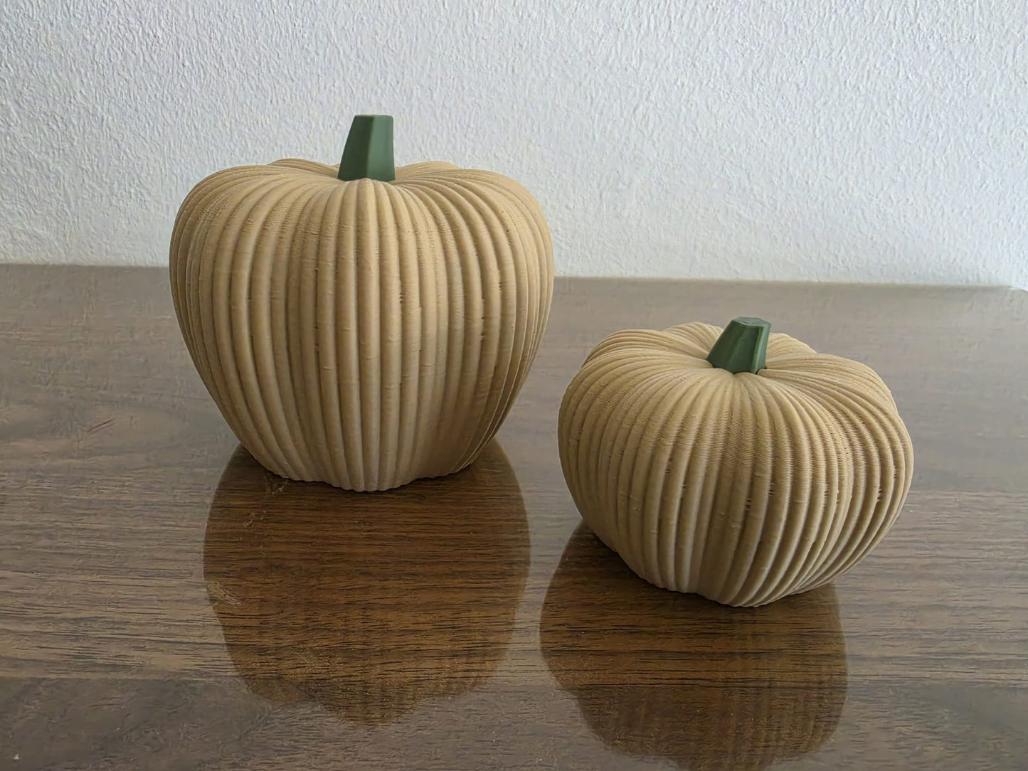 3D geprinte geribbelde pompoenen naturel groot en klein op houten tafel